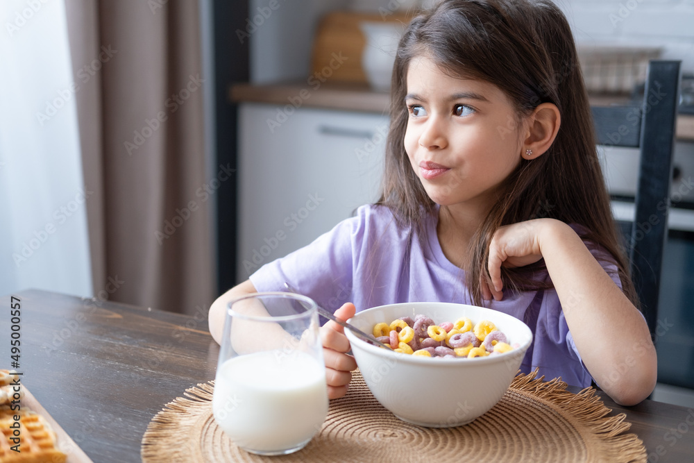 Happy arab child girl having breakfast colorful cereal with milk at home on the morning Happy arab child girl having breakfast colorful cereal with milk at home on the morning