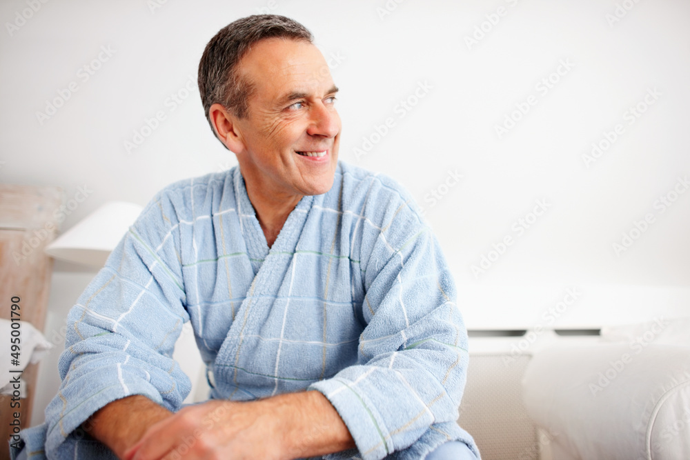 Smiling mature man wearing bathrobe while looking away. Closeup portrait of a smiling mature man wearing bathrobe while looking away. Smiling mature man wearing bathrobe while looking away. Closeup portrait of a smiling mature man wearing bathrobe while looking away.