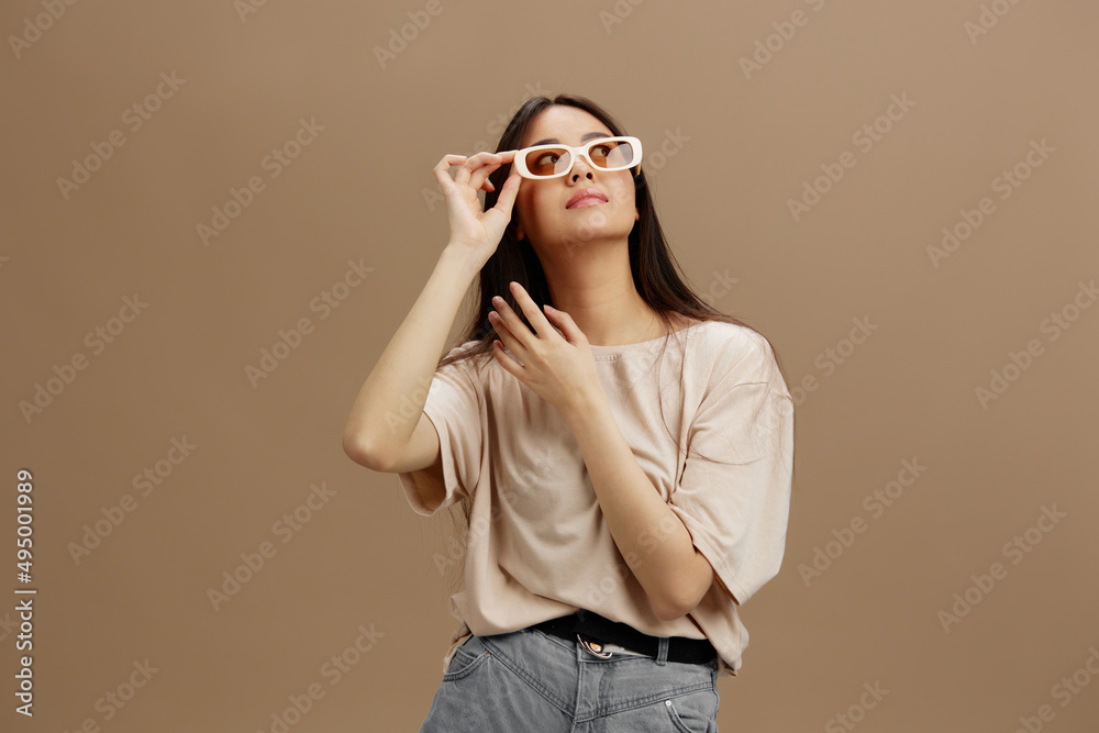 Fototapeta premium Brunette in a beige T-shirt with glasses posing clothing fashion Green background