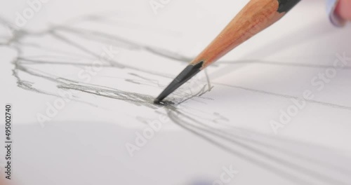 close-up of a pencil that draws the contours of the wedding dress design drawing. girl draws a sketch. close-up