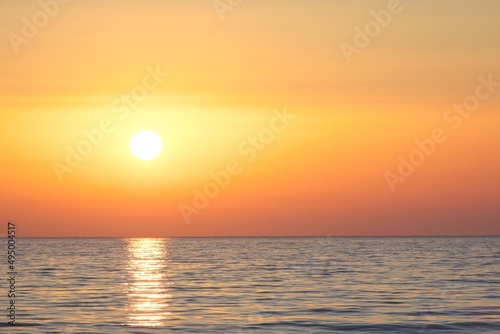 Calm sea in the evening. Hazy sun at sunset. © Igor