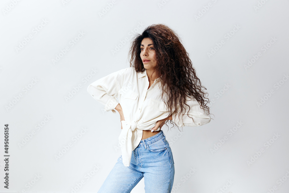 Sexy Curly Pretty Pensive Latin Female Lady in White Shirt tied in bow Holding Hands On Waist copy space, free place Looking Aside Isolated At White Studio Wall Background. Good Offer, Banner, Mockup Sexy Curly Pretty Pensive Latin Female Lady in White Shirt tied in bow Holding Hands On Waist copy space, free place Looking Aside Isolated At White Studio Wall Background. Good Offer, Banner, Mockup