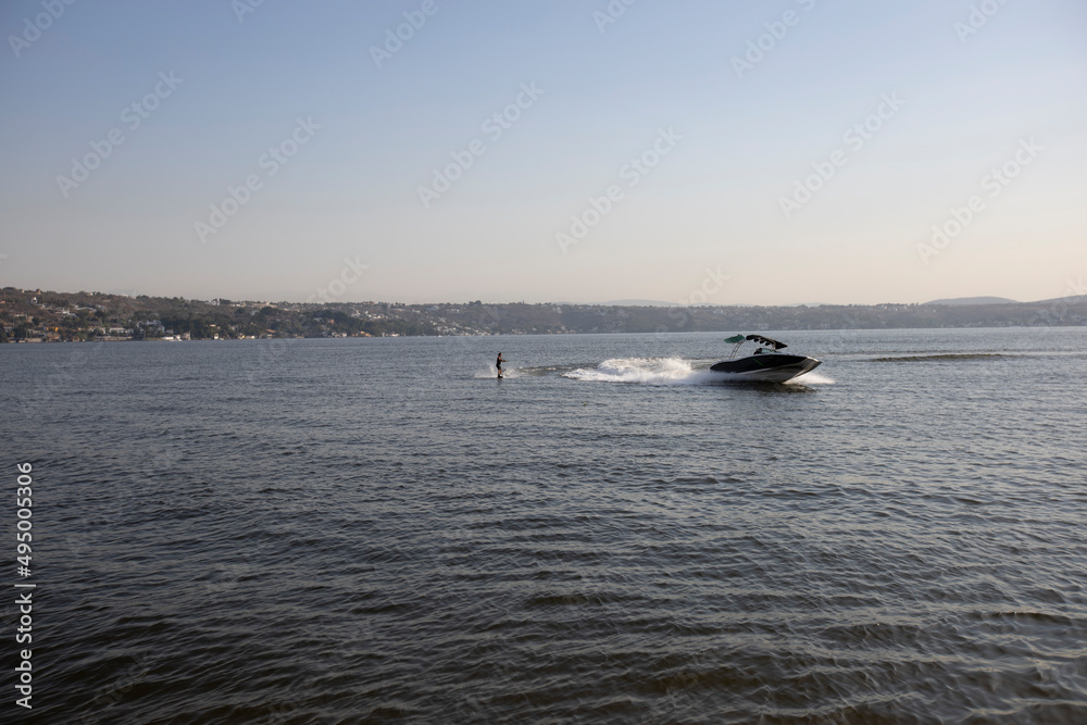 Water skiing. The boat pulls the sportsman.