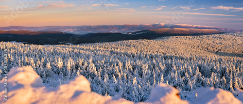 Winter landscape in the mountains at sunset, snow-capped mountain peaks and forest, the view from the observation tower.