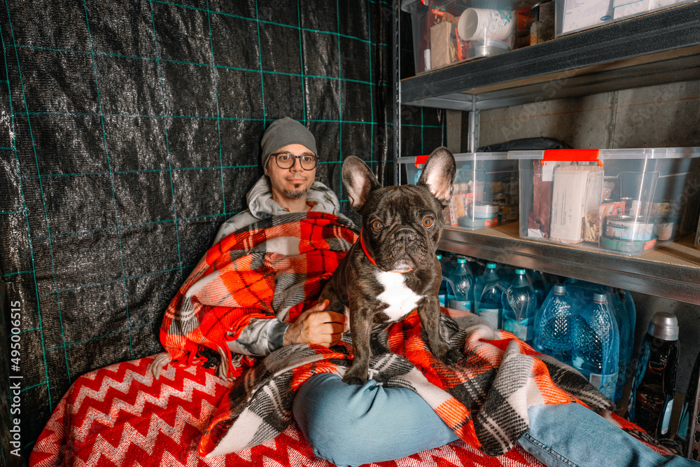 Man and french bulldog dog in underground emergency shelter