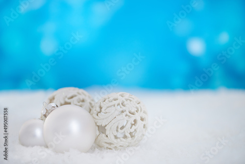 Wishing you a beautiful Christmas. Some christmas baubles lying on a bed of snow.