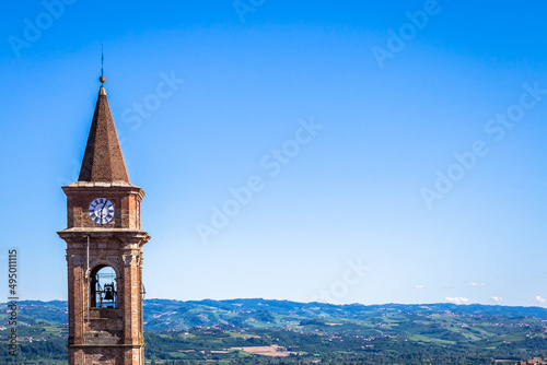 Piedmont hills in Italy with scenic countryside, vineyard field and blue sky. Govone bell tower on the left. photo