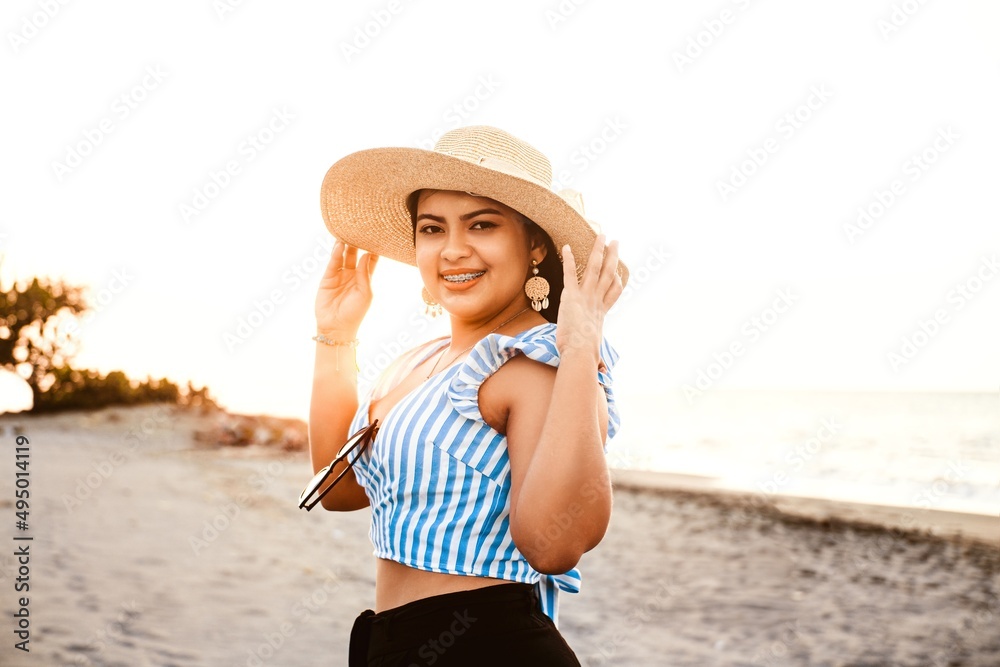 beauty young woman with brackets wearing a hat on the beach.