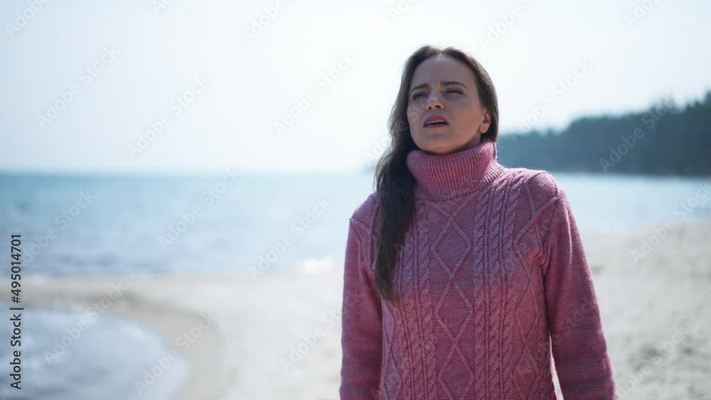 Front view portrait of confident Caucasian calm woman walking on sandy river coast looking away. Dolly shot of slim charming lady strolling outdoors in slow motion admiring nature Front view portrait of confident Caucasian calm woman walking on sandy river coast looking away. Dolly shot of slim charming lady strolling outdoors in slow motion admiring nature