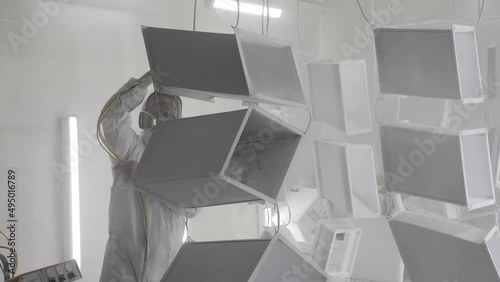 Powder coating of metal products. Industrial painting metal powder coating paint manufacturing process. Coveralls worker with spray gun painting parts metal workshop. Metalwork workpiece factory paint