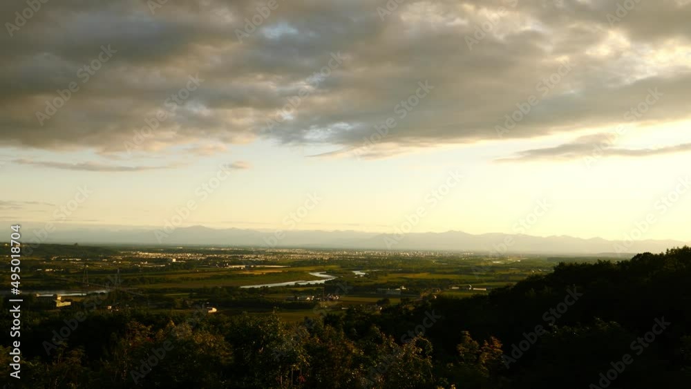 The cityscape of Obihiro and the evening view of the mountains seen from the Tokachigaoka Observatory in Hokkaido. (pan) The cityscape of Obihiro and the evening view of the mountains seen from the Tokachigaoka Observatory in Hokkaido. (pan)