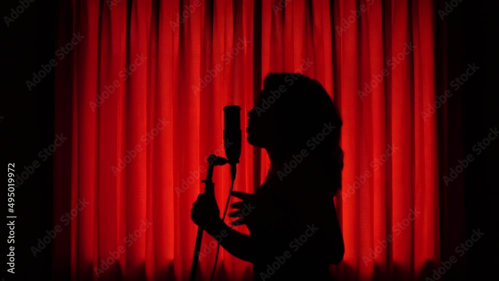 Mujer joven disfrutando del canto. Mujer cantando en estudio.