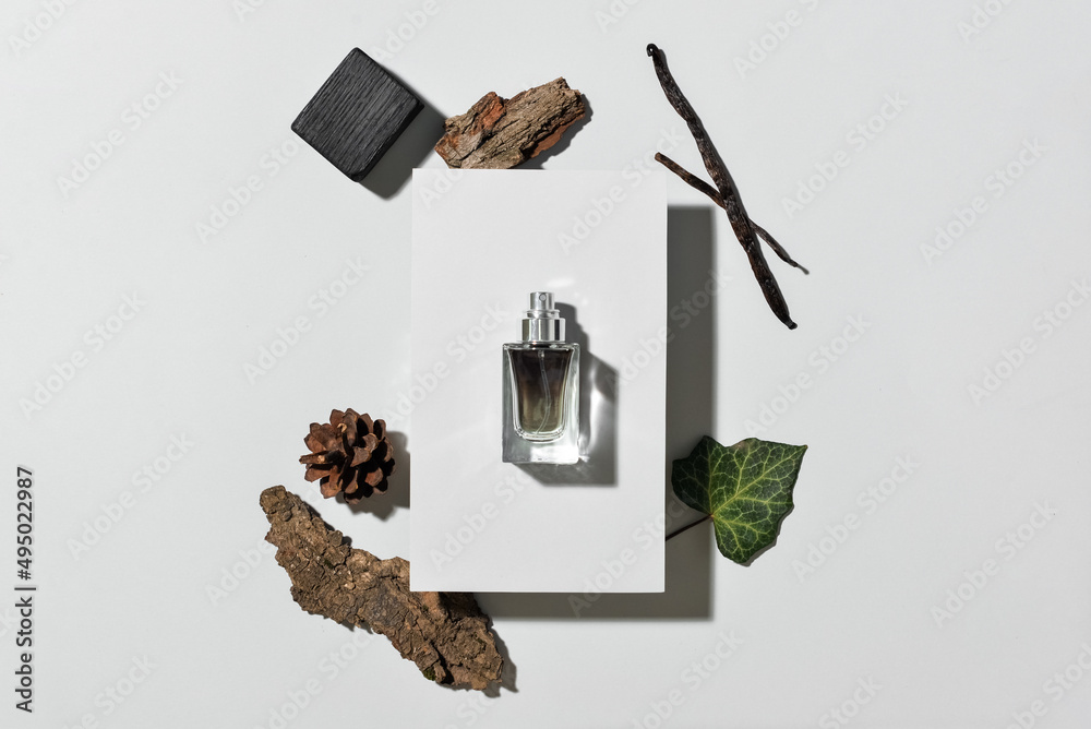 Bottle of woody perfume on light background, top view - obrazy, fototapety, plakaty 
