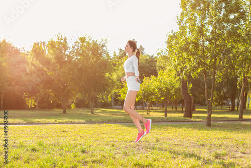 Sporty young woman skipping...