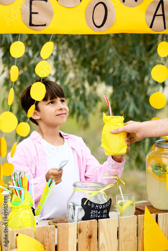 Cute boy selling lemonade i...