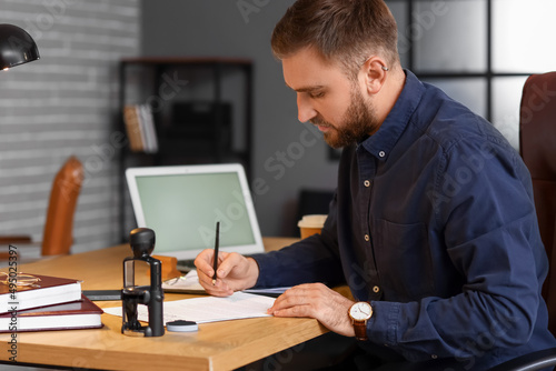 Male notary public working in office