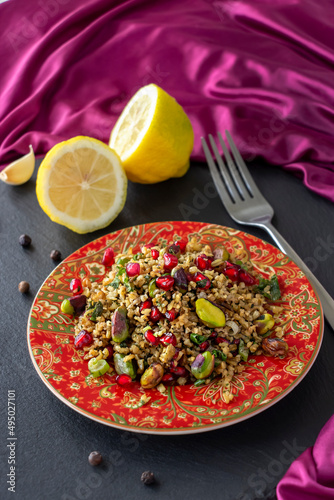 Freekeh, pomegranate seeds and pistachio healthy salad. Arabic, African and Arabic traditional cuisine. Copy space. Superfood concept.
