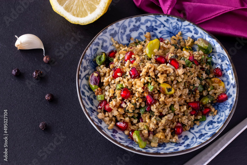Freekeh, pomegranate seeds and pistachio healthy salad. Arabic, African and Arabic traditional cuisine. Copy space. Superfood concept. photo