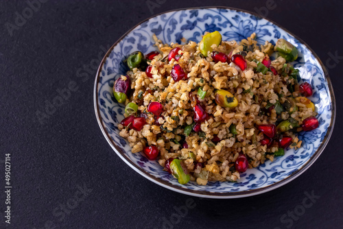 Freekeh, pomegranate seeds and pistachio healthy salad. Arabic, African and Arabic traditional cuisine. Copy space. Superfood concept.