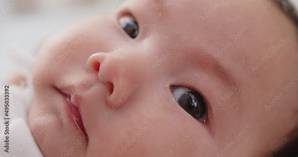 Close up macro portrait adorable newborn baby infant child girl face wakes up and opens his eyes looking at camera on the bed in the morning at home
Close up macro portrait adorable newborn baby infant child girl face wakes up and opens his eyes looking at camera on the bed in the morning at home