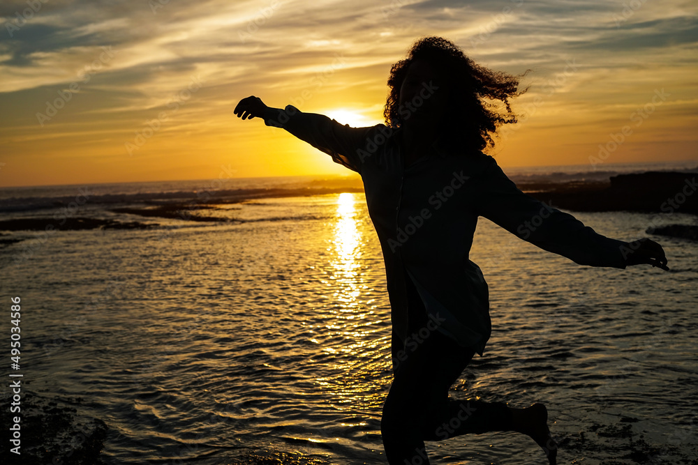 person dancing at the beach at sunset