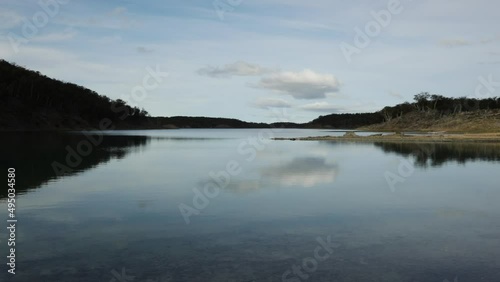 View of the forest and lake in a beautiful sunny day. The sky and clouds reflection in the water. photo