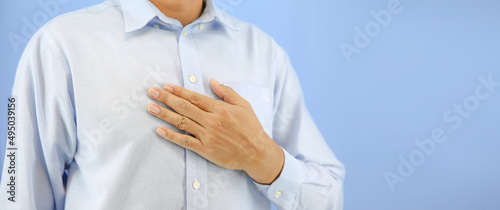 Hand holding the chest concepts of burning chest pain or sensation in middle of chest and health care for the treatment of illnesses from gastritis and gastroesophageal reflux disease. photo