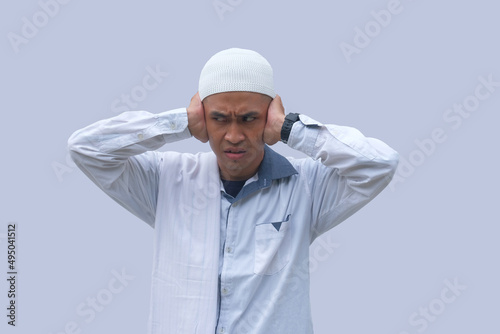 muslim man covering his ear with hand