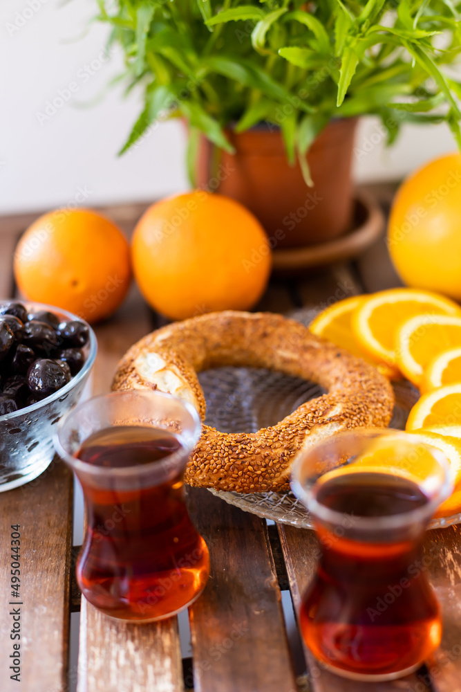 Turkish tea, sesame bagel, oranges and olives on wooden table