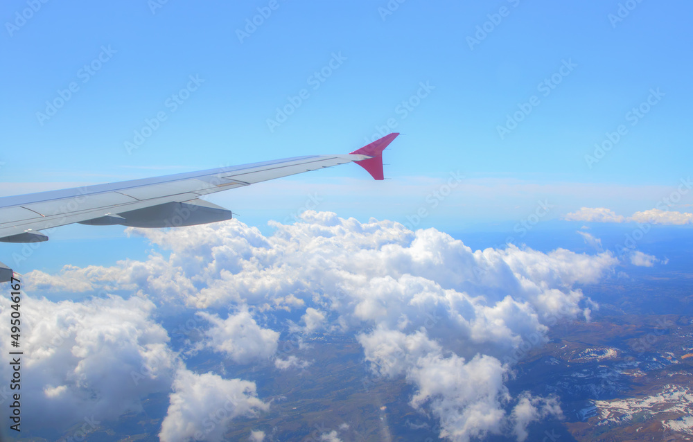 Fototapeta premium Airplane in the sky with wing over the blue sky