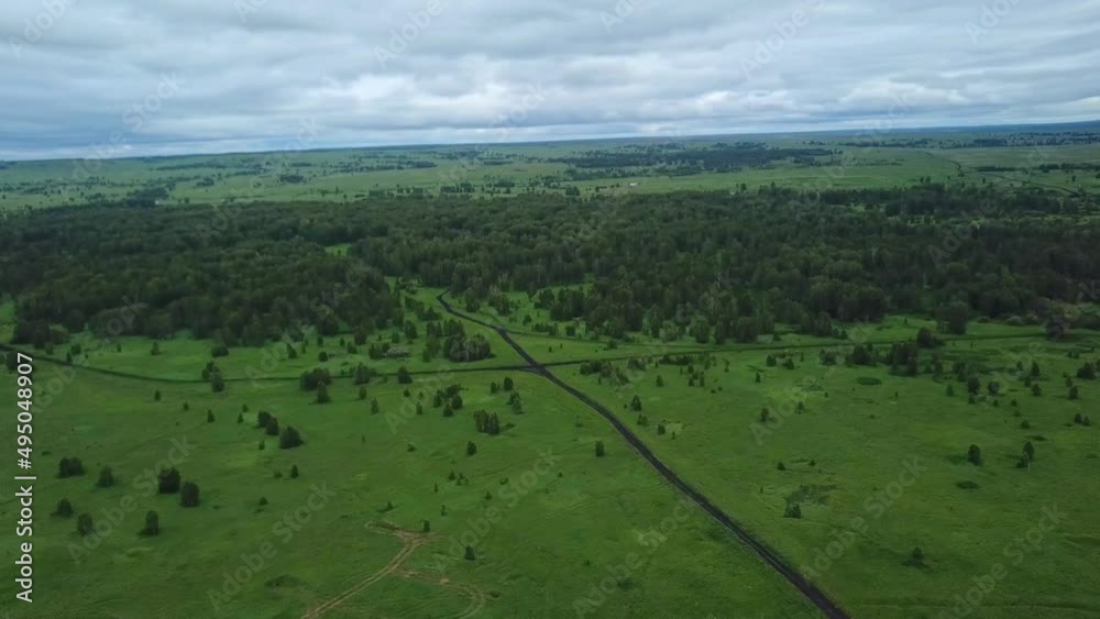 Gravel road surrounded green fields. Drone view of country road at rural scene. Gravel road surrounded green fields. Drone view of country road at rural scene.
