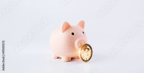 Save currency bitcoin. Pink pig bank with golden bit coin money BTC on white background. Save money investment and business finance.