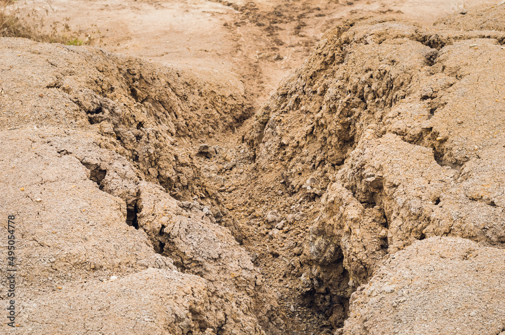 Arid landscape and Eroded soil concept. Background image of a dried cracked clay with traces from a erosion .Natural picture taken during the dry season. Arid landscape and Eroded soil concept. Background image of a dried cracked clay with traces from a erosion .Natural picture taken during the dry season.