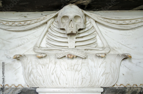 Photo Carving of a skeleton resting on an acanthus plinth