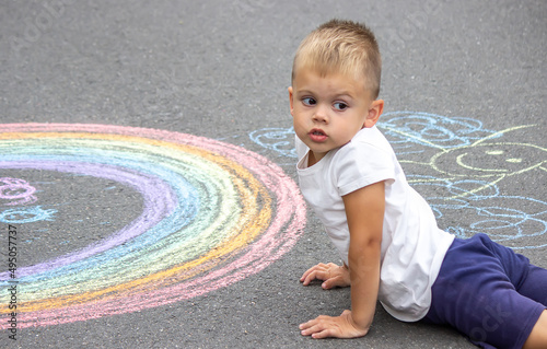 The child draws with chalk on the pavement.