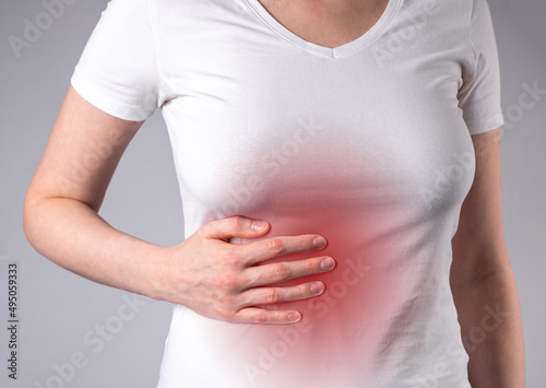 Wallpaper Mural Woman suffering from liver pain. Hand holding abdomen with red point closeup. Stomach ache. Inflammation, liver cirrhosis. Healthy lifestyle concept. High quality photo Torontodigital.ca