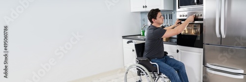 Fotobehang Disabled Man Using Microwave Oven In Kitchen
