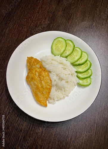 large vertical photo. dietary vegetarian food. basmati rice with vegetables. cucumber slices and asparagus on a round white plate. eco. healthy food.