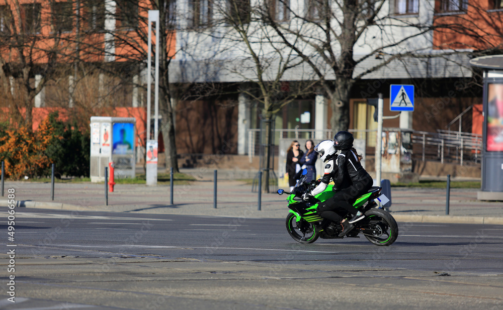 Motocyklista z pasażerem jedzie ulicą Wrocławia. - obrazy, fototapety, plakaty 