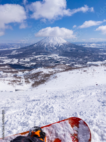 Overlooking at slopes and a snowy volcano from a off-piste area of mountaintop in a ski resort (Niseko, Hokkaido, Japan) photo
