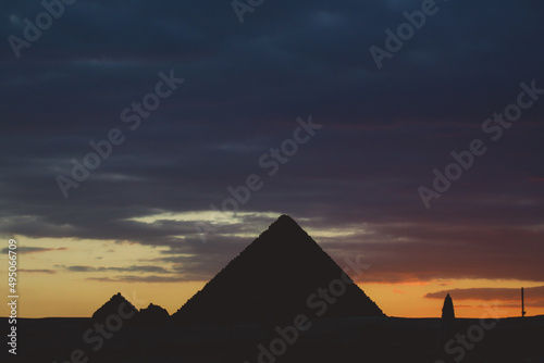 Sunset View to the One of the Wonders of the Ancient World - Great Pyramids of Giza with Colorful Sky and Evening Lights of the Sun  Egypt