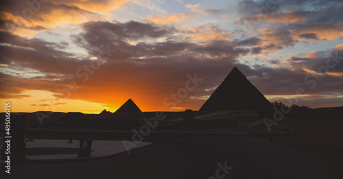 Sunset View to the One of the Wonders of the Ancient World - Great Pyramids of Giza with Colorful Sky and Evening Lights of the Sun  Egypt