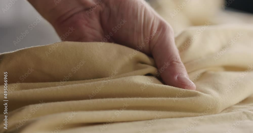 Slow motion man touching yellow cotton clothes closeup