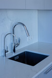 Silvery faucet and kitchen sink on modern kitchen