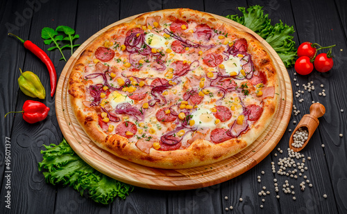 Pizza with quail eggs, ham, sausage and vegetables