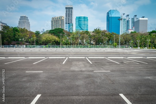 Empty space large outdoor asphalt car parking lot in city with city building background. Transport concept.