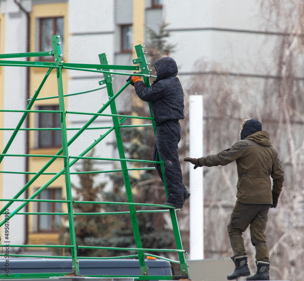 Workers install a metal frame for the Christmas tree in the city.