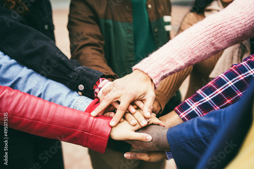 Bilde på lerret Young group of people stacking hands outdoor - Focus on hands