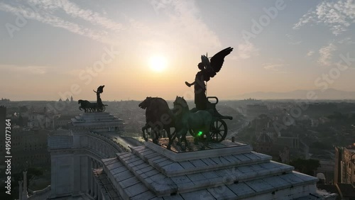 la statua con cavalli che domina l'Altare della Patria a Roma. 
Vista aerea controluce sul Foro Romano e colosseo con il sole dell'alba. photo
