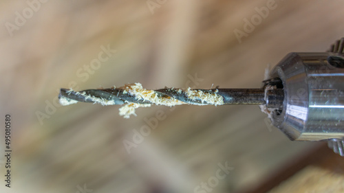 Close-up wood drill in sawdust. Drill chuck